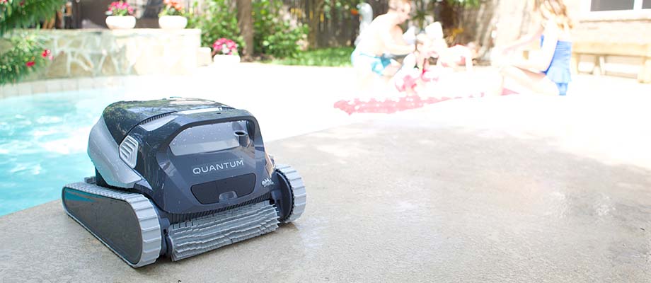 People relaxing beside a swimming pool with a robotic cleaner
