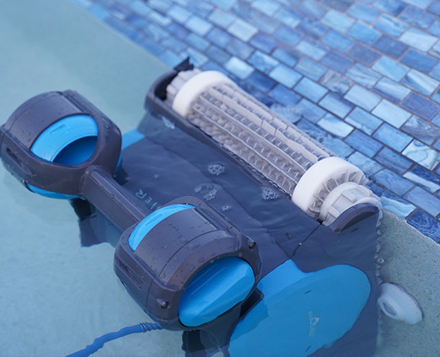 Dolphin pool robot scrubbing the waterline as it climbs a pool wall